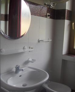 uma casa de banho com um lavatório, um espelho e um WC. em Residenze Sonnenschein Casa Bianca em Villabassa