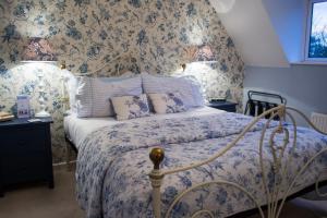 a bedroom with a bed with blue floral wallpaper at Beachlands Hotel in Weston-super-Mare