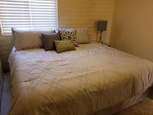 a large bed with pillows on it in a bedroom at Tucson Airport Oasis in Tucson