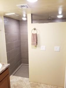a bathroom with a shower with a towel on the wall at Tucson Airport Oasis in Tucson