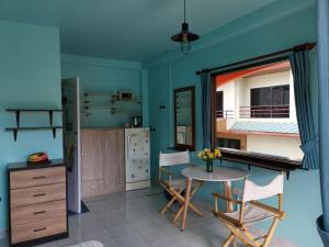 a kitchen with blue walls and a table and chairs at myPatong Social Hostel in Patong Beach