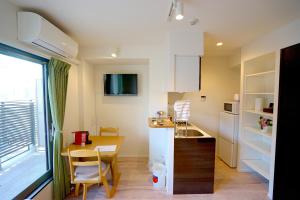 a small kitchen with a desk and a table and a window at Jeffery Skytree Residence Tokyo in Tokyo