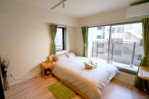 Jeffery Skytree Residence Tokyo في طوكيو: غرفة نوم بسرير ونافذة كبيرة