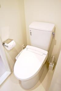 Jeffery Skytree Residence Tokyo في طوكيو: مرحاض أبيض في حمام مع لفة من ورق التواليت