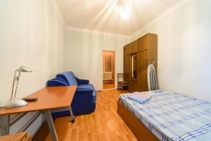a bedroom with a bed and a desk and a chair at Квартира по адресу ул. Черняховского 12 in Kyiv