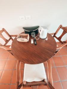 una mesa de madera con sillas y una cafetera. en La Norita en Balcarce