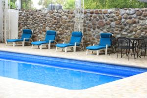 a group of chairs and tables next to a swimming pool at Hotel El Molino in Río Verde