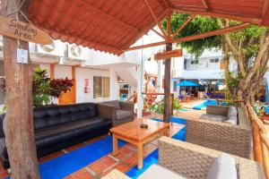 un patio con un sofá negro, sillas y una mesa en Hotel La Casa de Judy, en Puerto Ayora