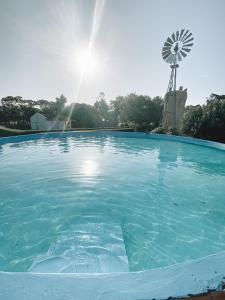 una piscina con un molino de viento de fondo en La Norita en Balcarce