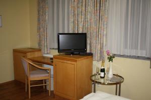 a hotel room with a desk with a television on it at Hotel Mykonos in Eschweiler