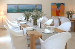 a dining room with a table and white chairs at Elies Resorts in Vathi