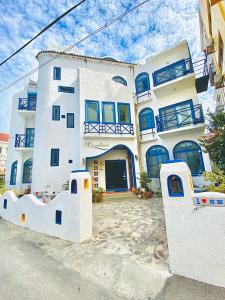 a large white building with blue windows at Morpheus B&B in Kenting