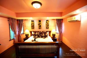 a bedroom with a bed with two lamps on it at Love Bridge House บ้านสะพานรัก in Sangkhla Buri