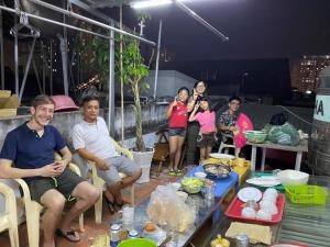 Un groupe de personnes assises autour d'une table dans l'établissement Nhat an Homestay, à Hô-Chi-Minh-Ville