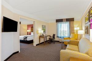 a hotel room with a bed and a living room at La Quinta Inn & Suites by Wyndham Panama City in Panama City