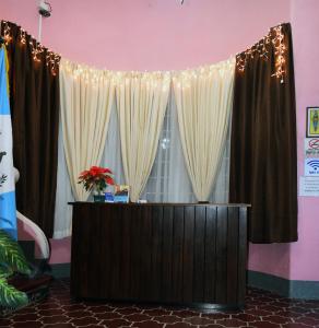 a reception desk with curtains and lights at Hotel Fuentes in Guatemala