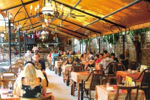 a group of people sitting at tables in a restaurant at Kleopatra Fatih Hotel in Alanya