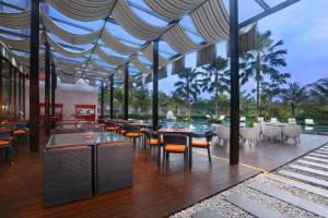 un restaurante con mesas y sillas en Harper Purwakarta by ASTON, en Purwakarta