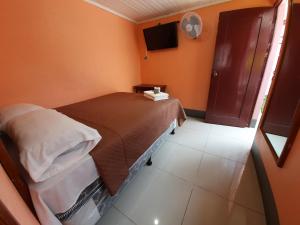 危地马拉Hotel Fuentes的一间有一张床和一台电视的小房间