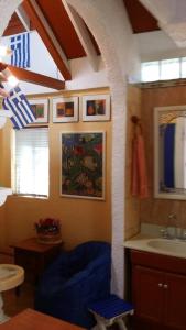 a bathroom with a blue chair and a sink at Greek Cottage Playas de Tijuana in Tijuana