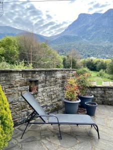 a bench sitting on a stone wall with potted plants at Papigo Stonehouse in Papigko