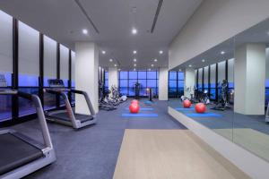 un gimnasio con cintas de correr y equipos de ejercicio en una habitación en Quest Prime Cikarang by ASTON en Bekasi