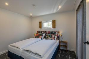 a bedroom with a large bed in a room at Welcome in - Vakantiewoning met grote tuin en green egg I Lepelstraat 18c Vrouwenpolder in Vrouwenpolder