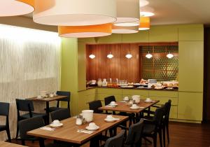 a restaurant with wooden tables and chairs and a counter at Hotel Henry in Dreieich