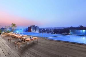 a pool on the roof of a building with benches at Aston Inn Pandanaran in Semarang