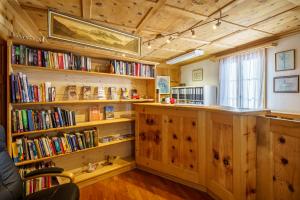 een bibliotheek met houten planken gevuld met boeken bij Hotel Silvapina in Klosters