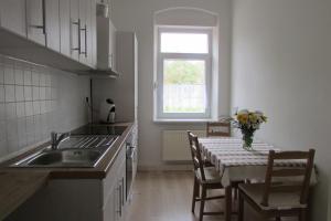 a kitchen with a table with a vase of flowers on it at NoOaks in Meißen