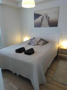 a bedroom with a white bed with two towels on it at Lutakko Apartment with free car parking in Jyväskylä