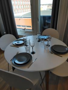 a white table with plates and wine glasses on it at Lutakko Apartment with free car parking in Jyväskylä