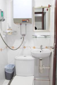 Baño blanco con aseo y lavamanos en Pay-Less Guesthouse (7/F A9), en Hong Kong