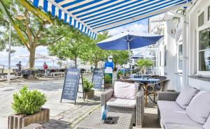 a patio with a table and chairs and an umbrella at Hotel Gastmahl des Meeres in Sassnitz
