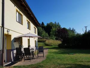 a patio with a table and chairs and an umbrella at Ubytování U Šustrů in Horní Maršov