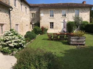 a garden with a table and chairs in front of a building at La Boulangeraie in Saint-Junien