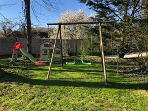 einen Spielplatz mit Schaukel im Hof in der Unterkunft Le charme d'othe in Bellechaume