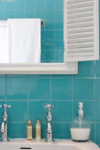 a bathroom sink with two faucets and a mirror at Magnolia Guesthouse in Lisbon