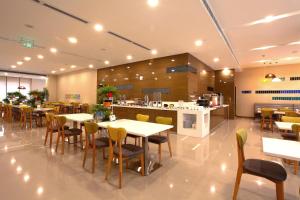 西安西安高新智选假日酒店的一间有桌椅和厨房的餐厅