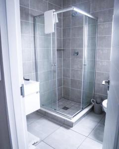 una doccia con una porta in vetro in un bagno di Serenity@TheBlyde a Pretoria