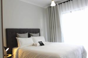 una camera da letto con un letto bianco e un libro sopra di Serenity@TheBlyde a Pretoria Altre 54 foto