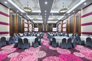 una sala de banquetes con mesas y sillas en una habitación con alfombra rosa en favehotel Sidoarjo en Sidoarjo