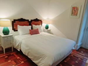 a bedroom with a large white bed with two night stands at Magnolia Guesthouse in Lisbon