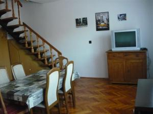 ティサフュレドにあるHoliday home Sellő Vendégházのリビングルーム(テーブル、ドレッサー内のテレビ付)