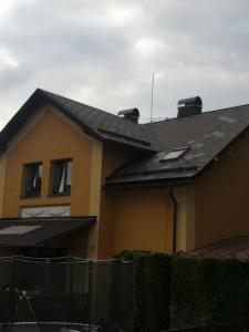 una casa amarilla con techo negro en Apartmánový dům Velké Losiny, en Velké Losiny