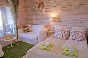 a bedroom with a white bed and a chair at Lavender Village in Kiemeliai