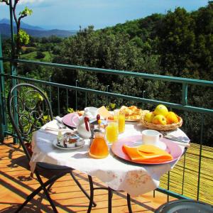 a table with a breakfast of fruit and juice on a balcony at Nonna Lelletta in Lanusei