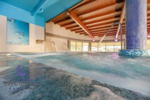 ein großes Schwimmbecken in einem Gebäude mit einer Decke in der Unterkunft Hotel Spa Norat Torre Do Deza 4* Superior in Lalín