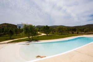 a large swimming pool in a field with trees at Eight Dimensions Capari Suites Elafonisos in Elafonisos